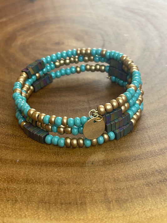 Turquoise and gold tone seed bead wrap bracelet with colorful hematite cube beads and a round charm.