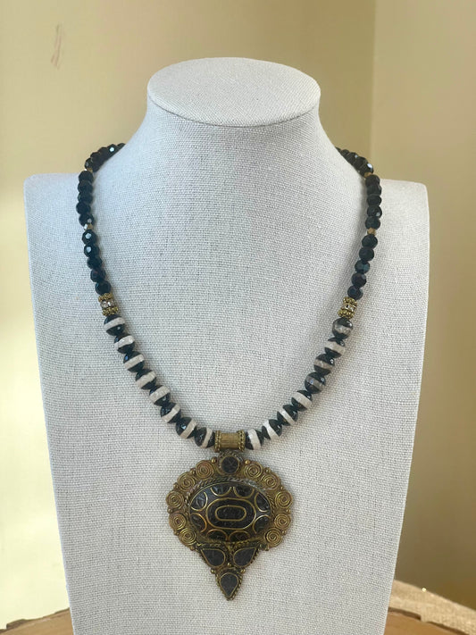 Black tourmaline and agate pendant necklace displayed on jewelry bust.