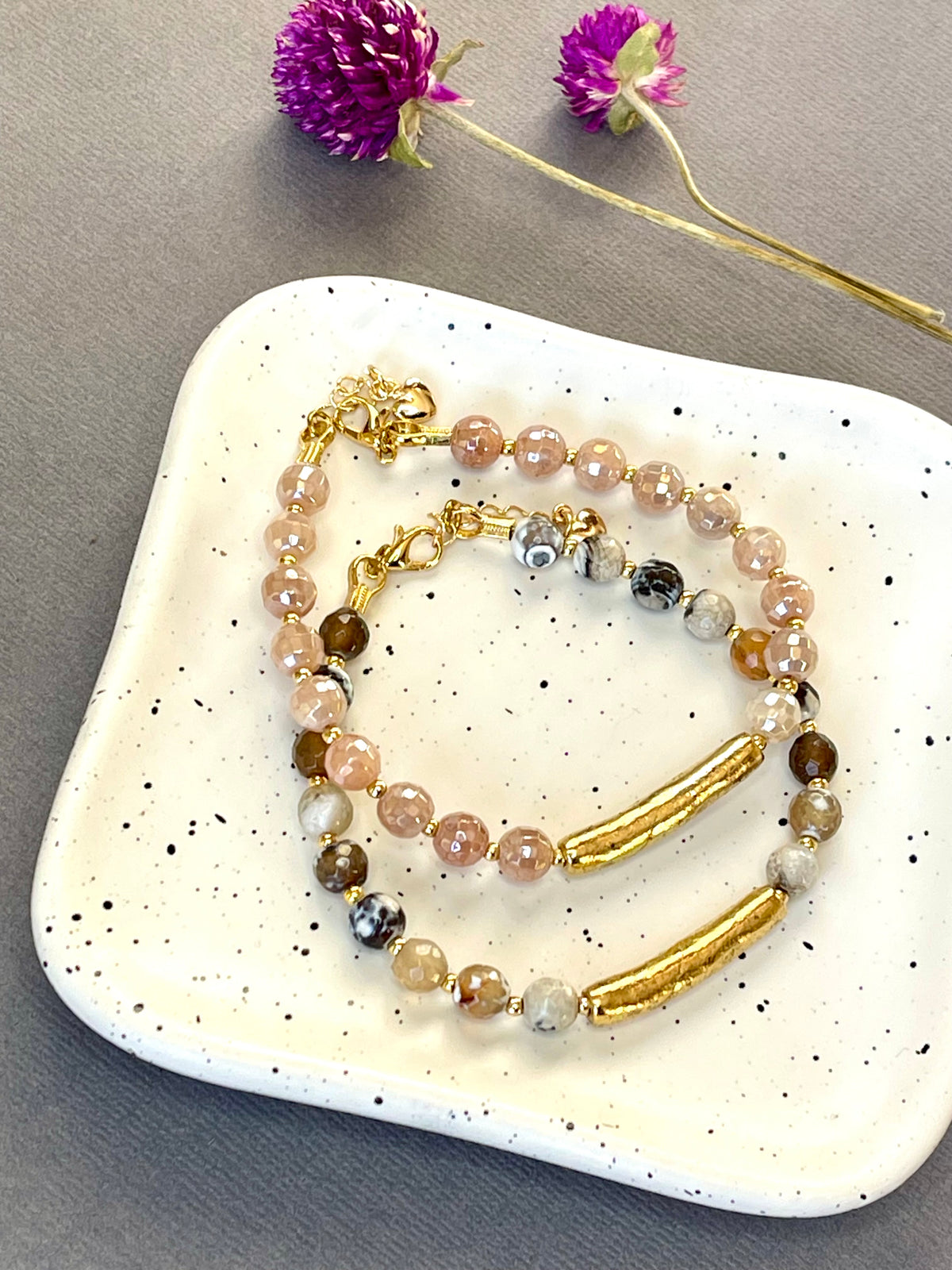 Peach moonstone and spotted agate bead bracelets with textured gold tone bars and adjustable clasps