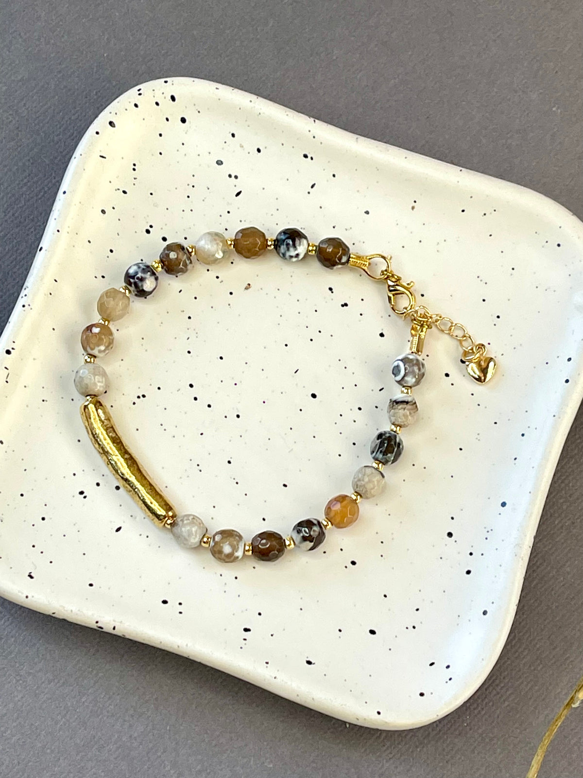 Peach moonstone and spotted agate bead bracelets with textured gold tone bars and adjustable clasps