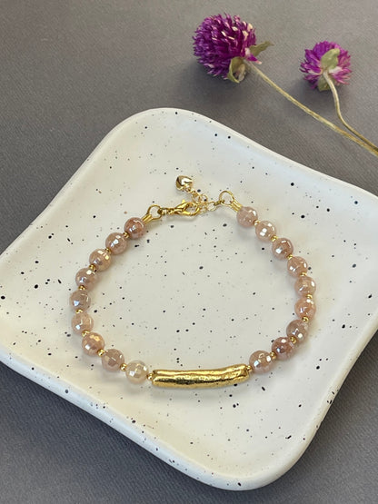 Peach moonstone and spotted agate bead bracelets with textured gold tone bars and adjustable clasps