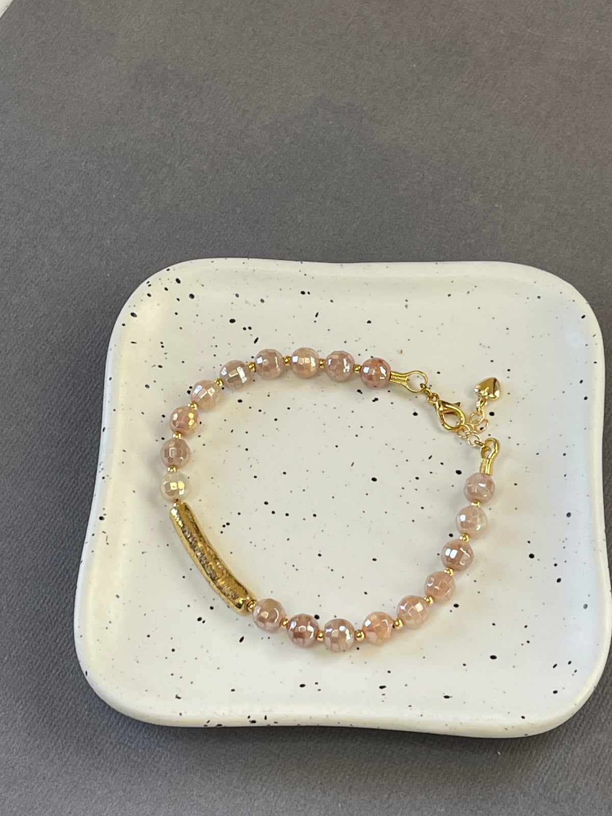 Peach moonstone and spotted agate bead bracelets with textured gold tone bars and adjustable clasps