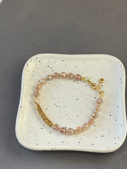 Peach moonstone and spotted agate bead bracelets with textured gold tone bars and adjustable clasps