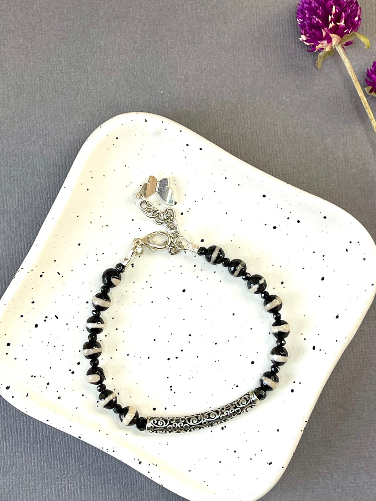  Black and white striped agate bead bracelet with an ornate silver plated bar and charm
