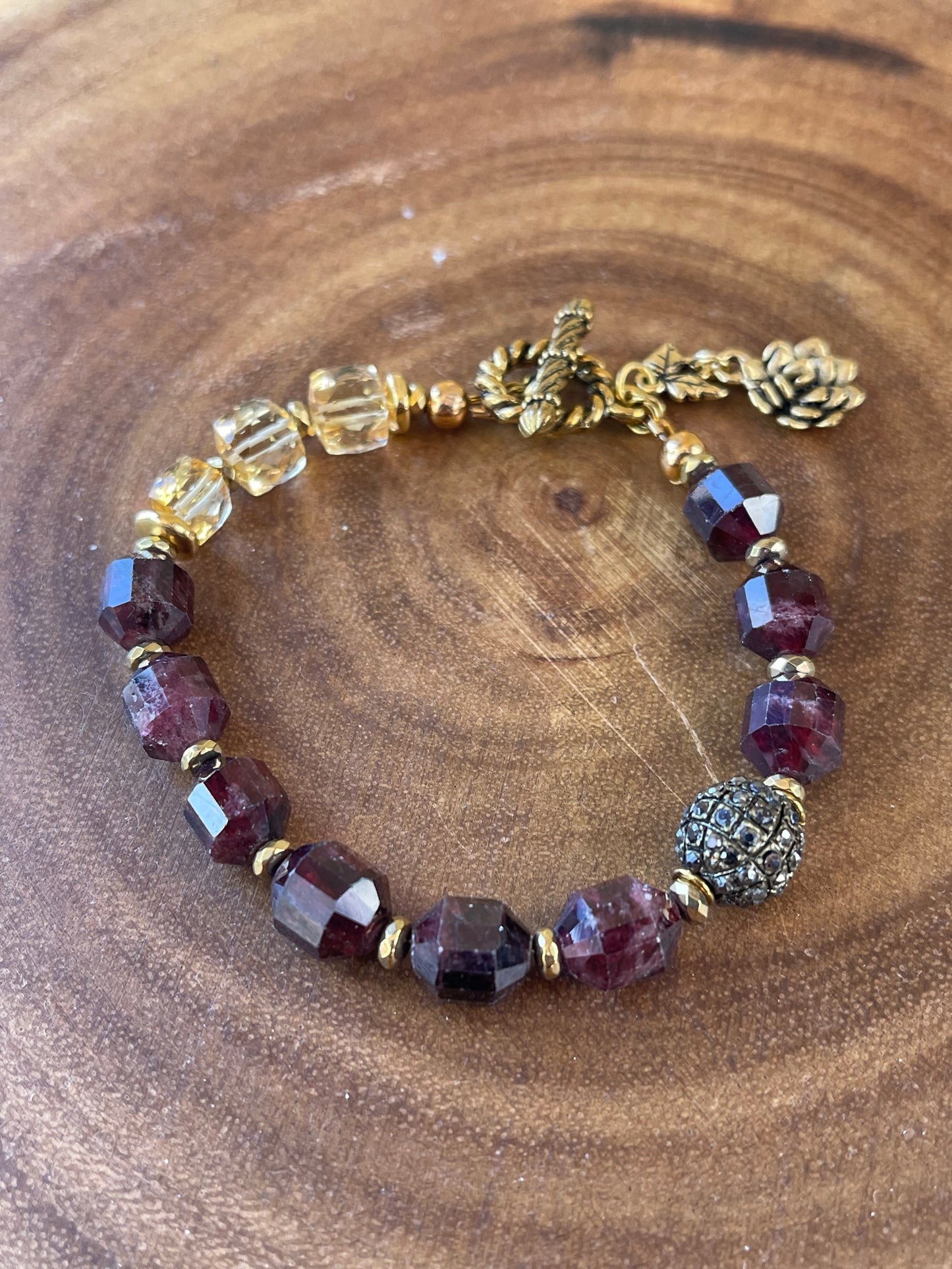 Close up of garnet gemstone beads and flower charm bracelet