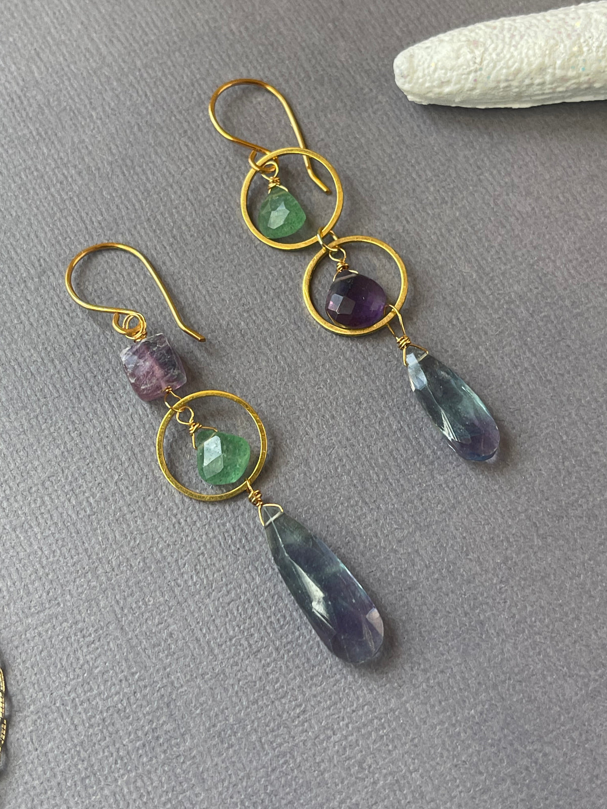 Gold tone dangle earrings featuring green strawberry quartz, amethyst and fluorite