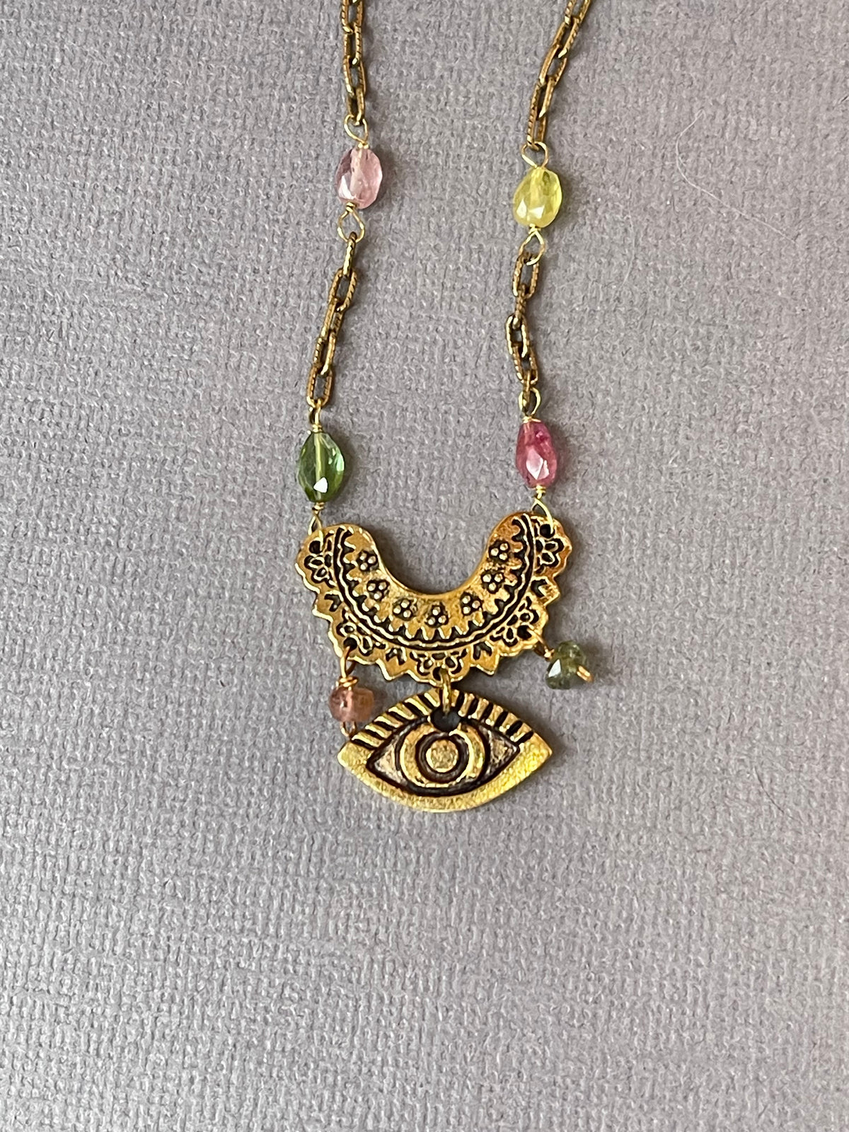 Rainbow tourmaline evil eye necklace close-up