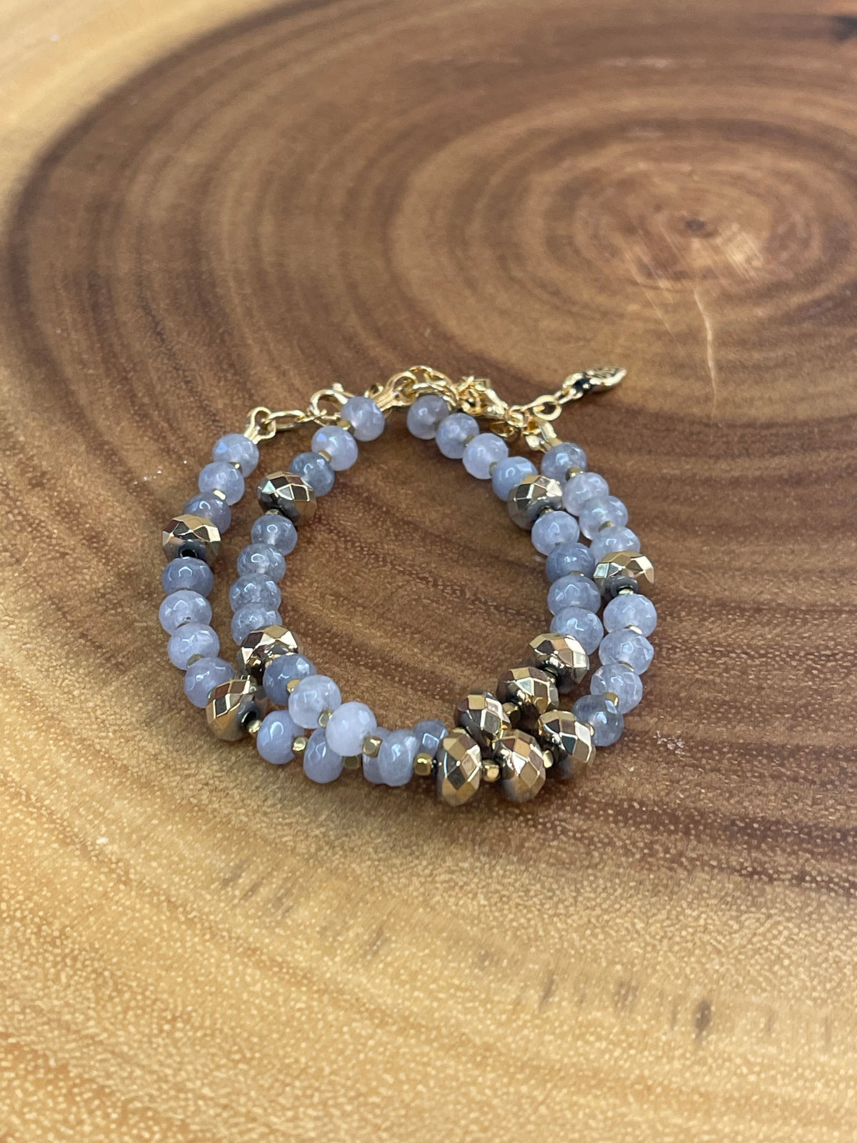 Gray faceted agate and gold hematite beaded bracelet with brass accents, gold plated clasp, and extender chain.