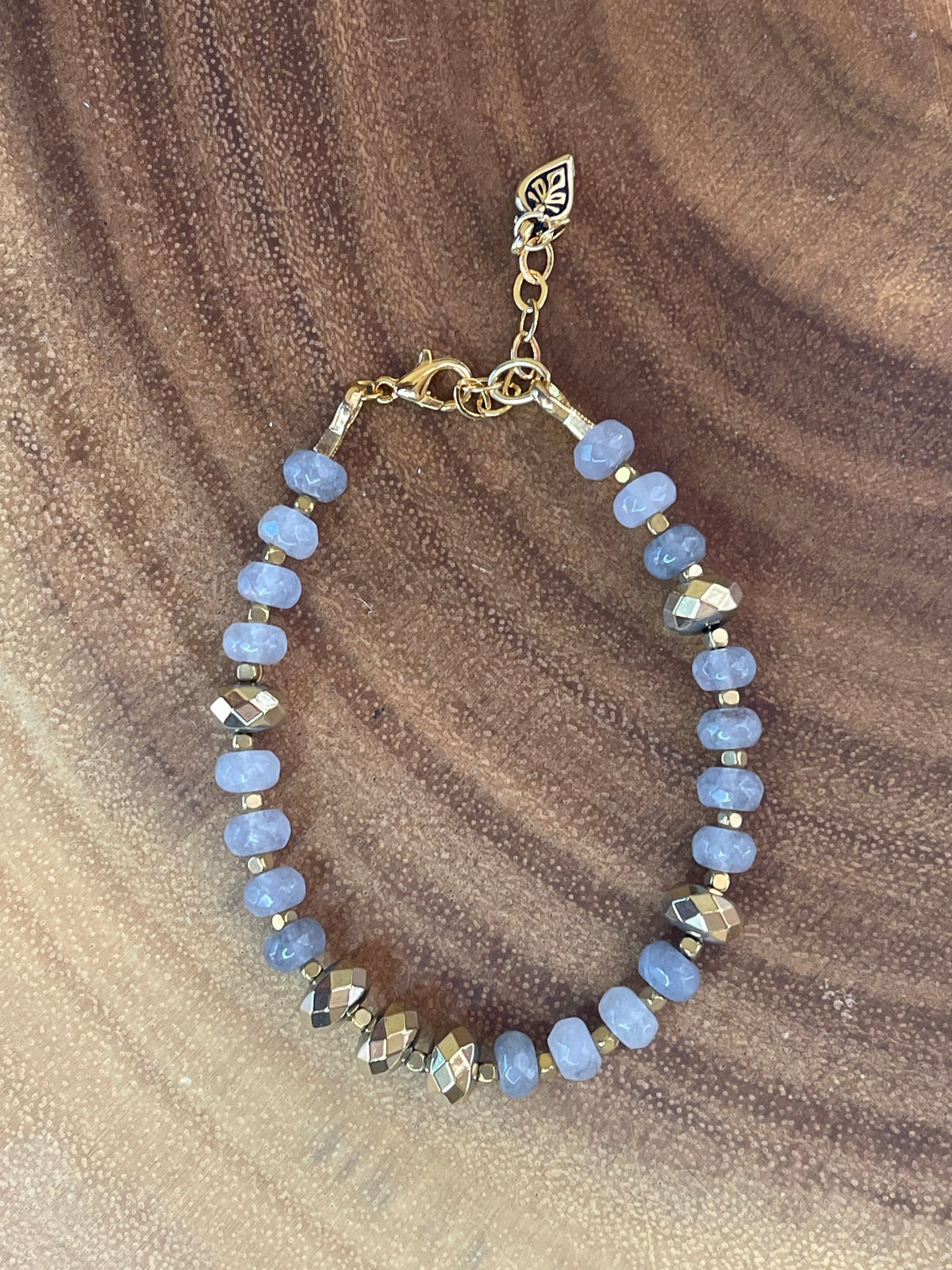 Gray faceted agate and gold hematite beaded bracelet with brass accents, gold plated clasp, and extender chain.