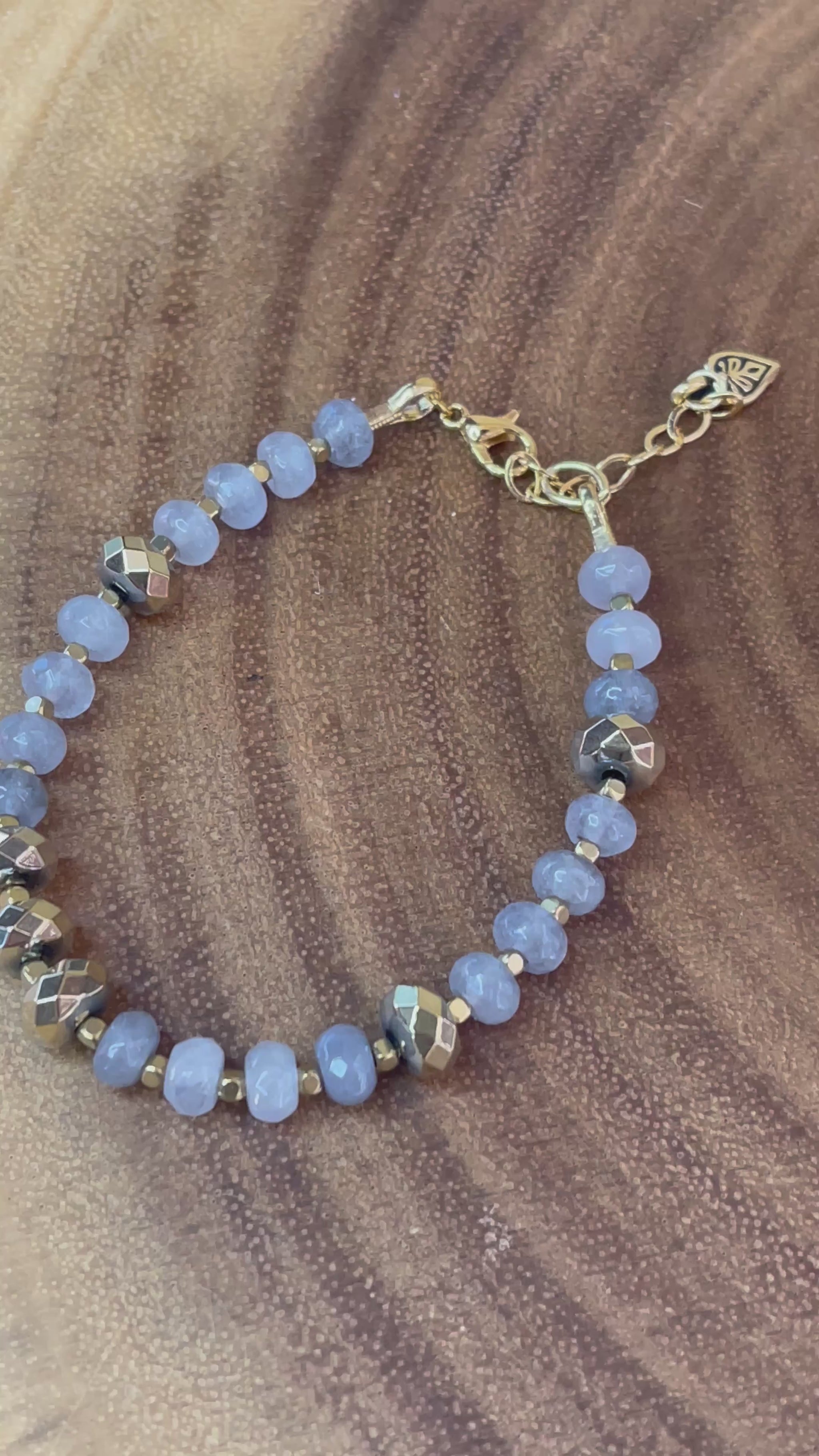 Gray faceted agate and gold hematite beaded bracelet with brass accents, gold plated clasp, and extender chain.