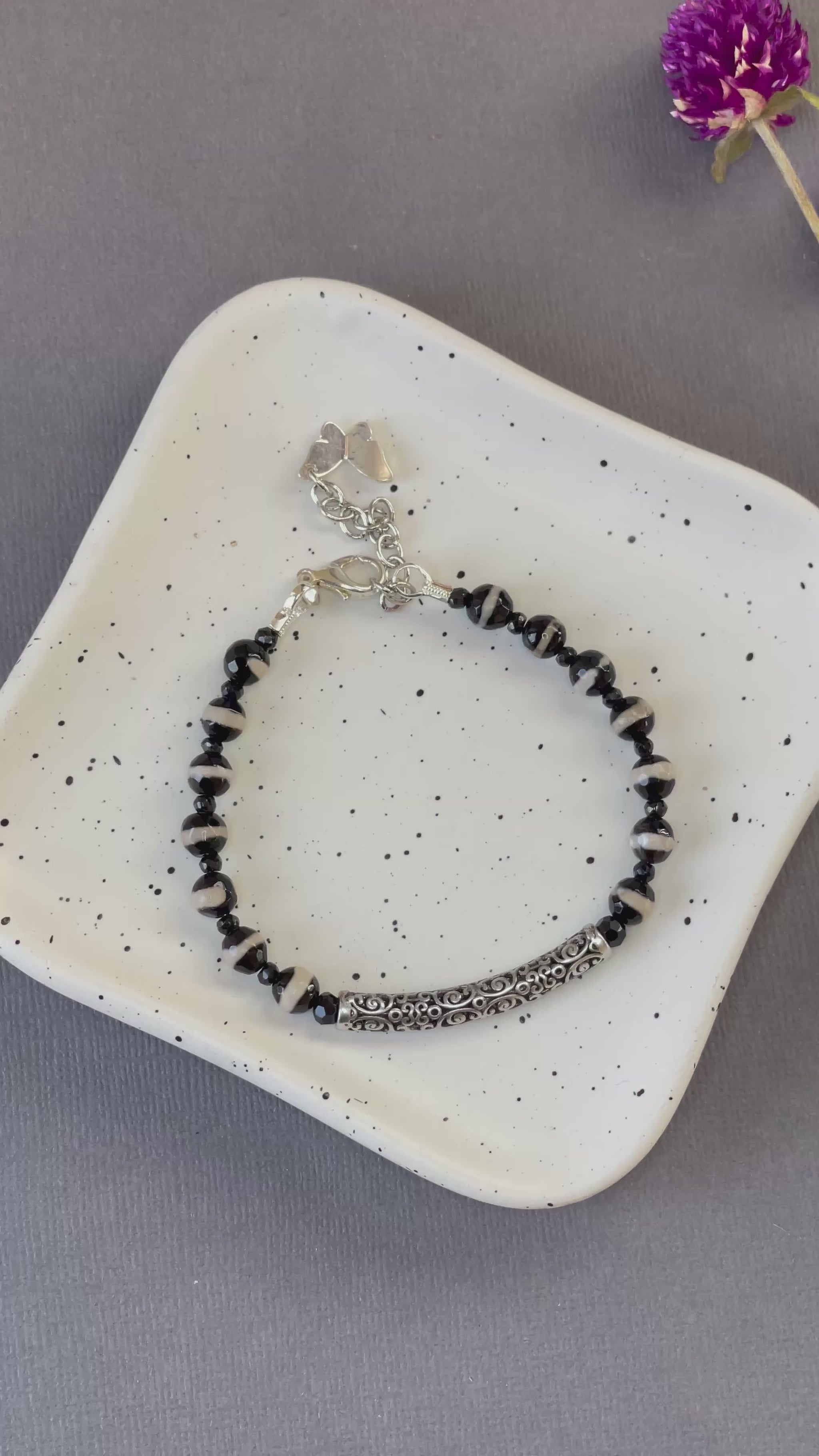 Black and white striped agate bead bracelet with an ornate silver plated bar and charm
