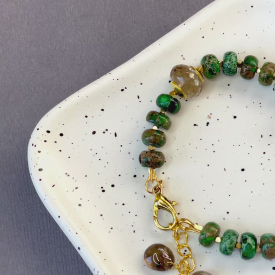 Green imperial jasper and smoky quartz stretch bracelet with gold-plated accents and brass charm