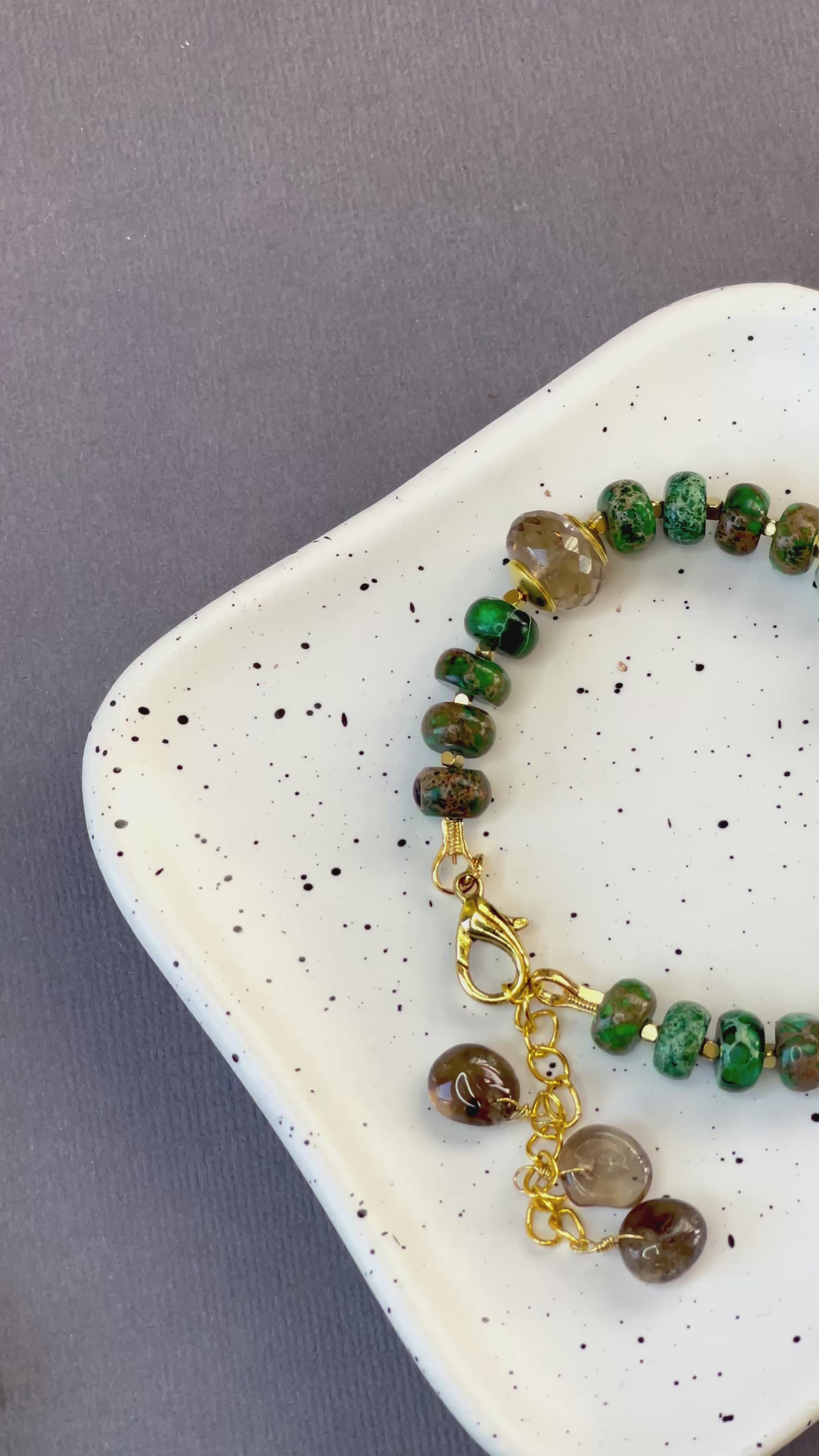 Green imperial jasper and smoky quartz stretch bracelet with gold-plated accents and brass charm