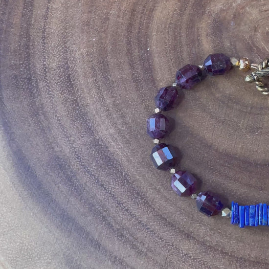 Close up of garnet gemstone beads and blue accents on bracelet